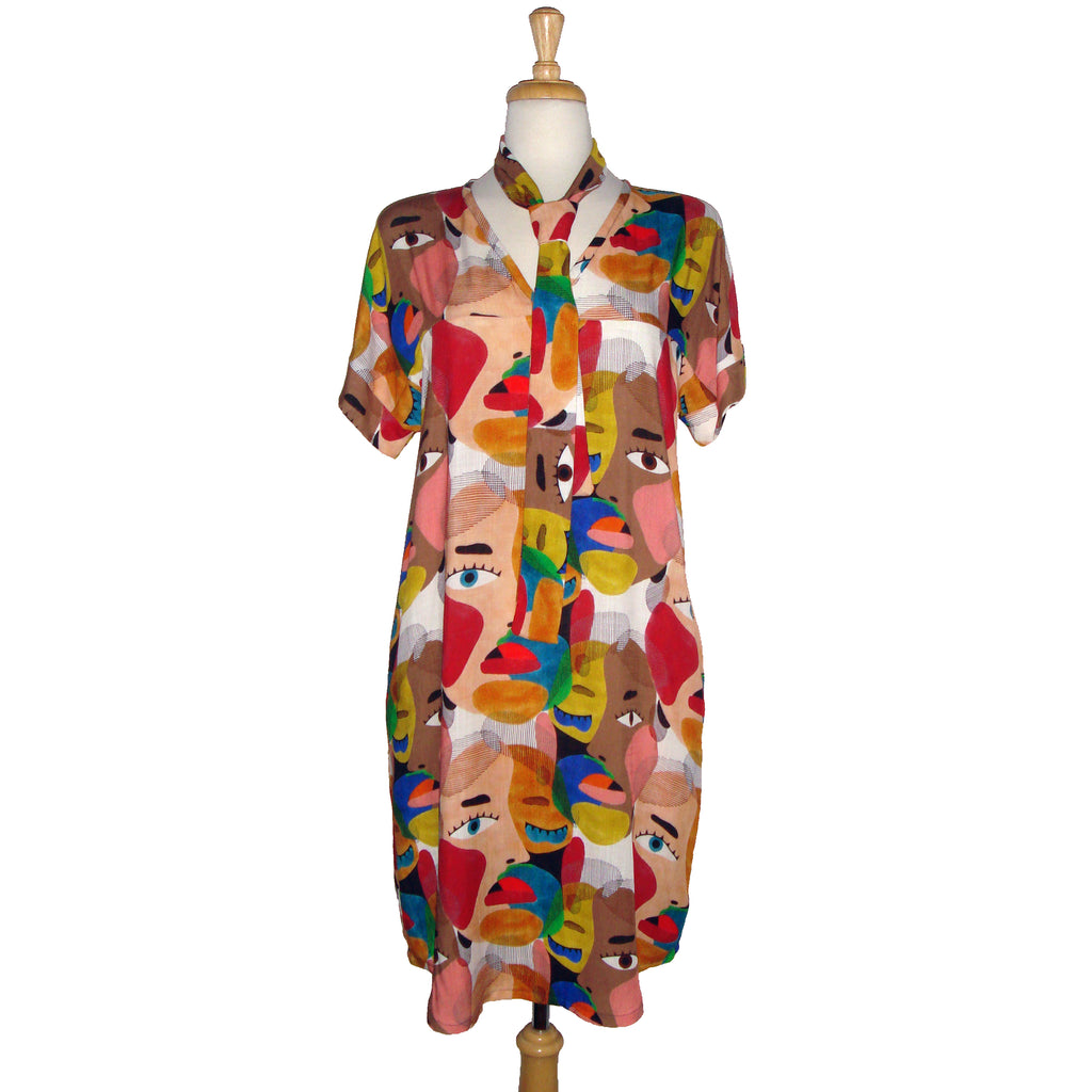 Face printed dress with pockets. Diversity print. multi cultural print. Short sleeve. v-neck. fun and unique dress. loose fitting dress. tunic dress. fun printed tunic dress. Belted dress. Long belted shirt dress.